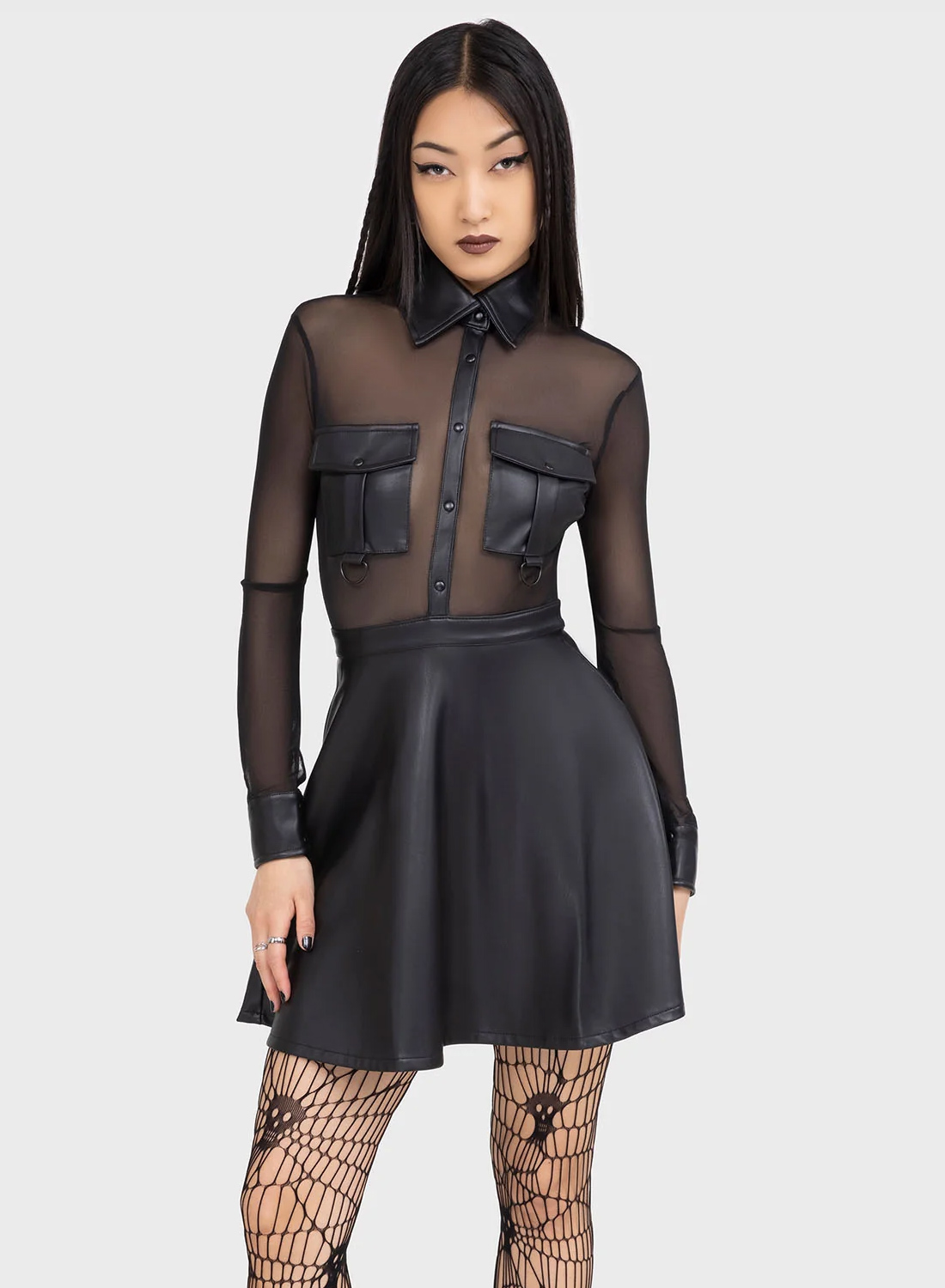 Killstar Shadowsinger-Kleid. Schwarzes Minikleid mit transparentem Mesh-Oberteil und PU-Rock, langen Ärmeln und Knopfdetails von Killstar.